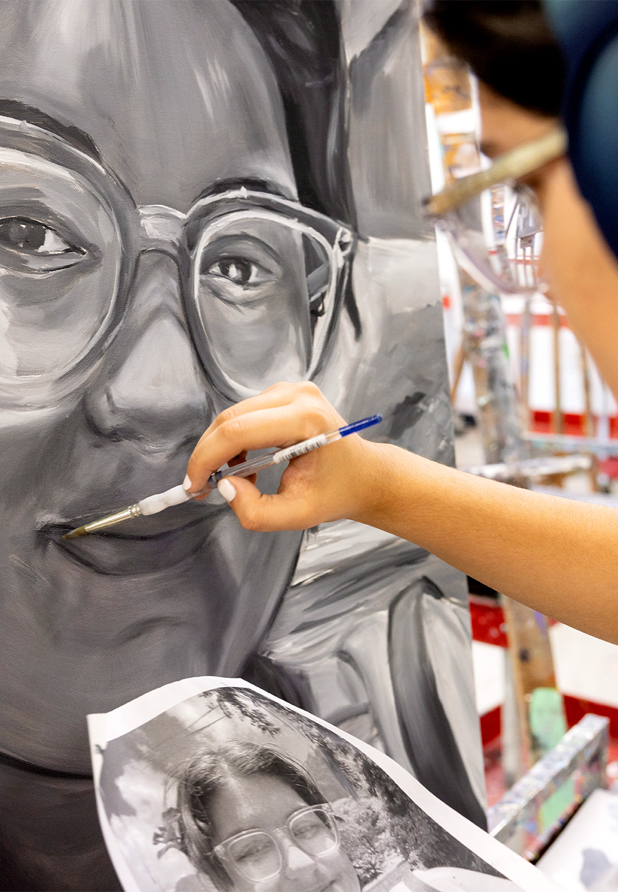 Jennifer Vega, who is studying motion pictures and advertising with a minor in art, works on the finishing touches of her black-and-white self-portrait during the class Art 202 taught by Brian Curtis, associate professor of painting and drawing.